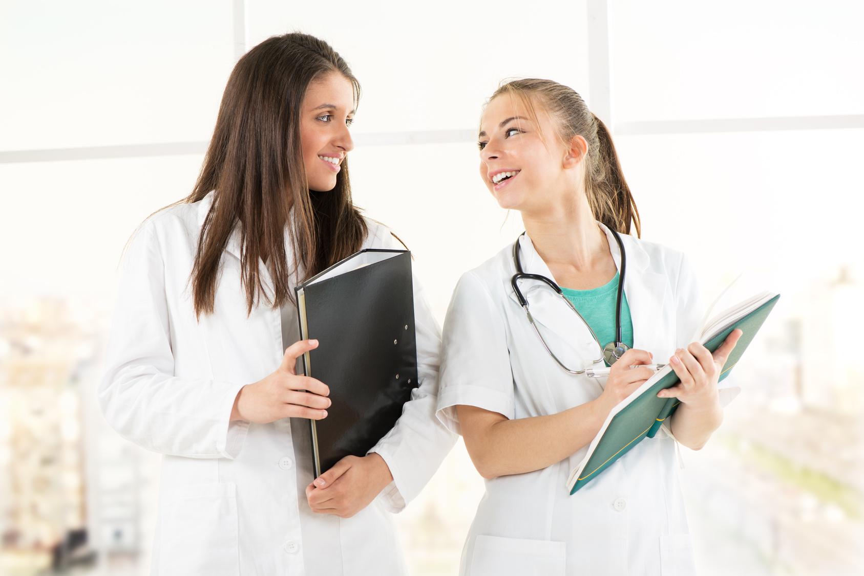 Zdjęcie przedstawia dwie pielęgniarki rozmawiające